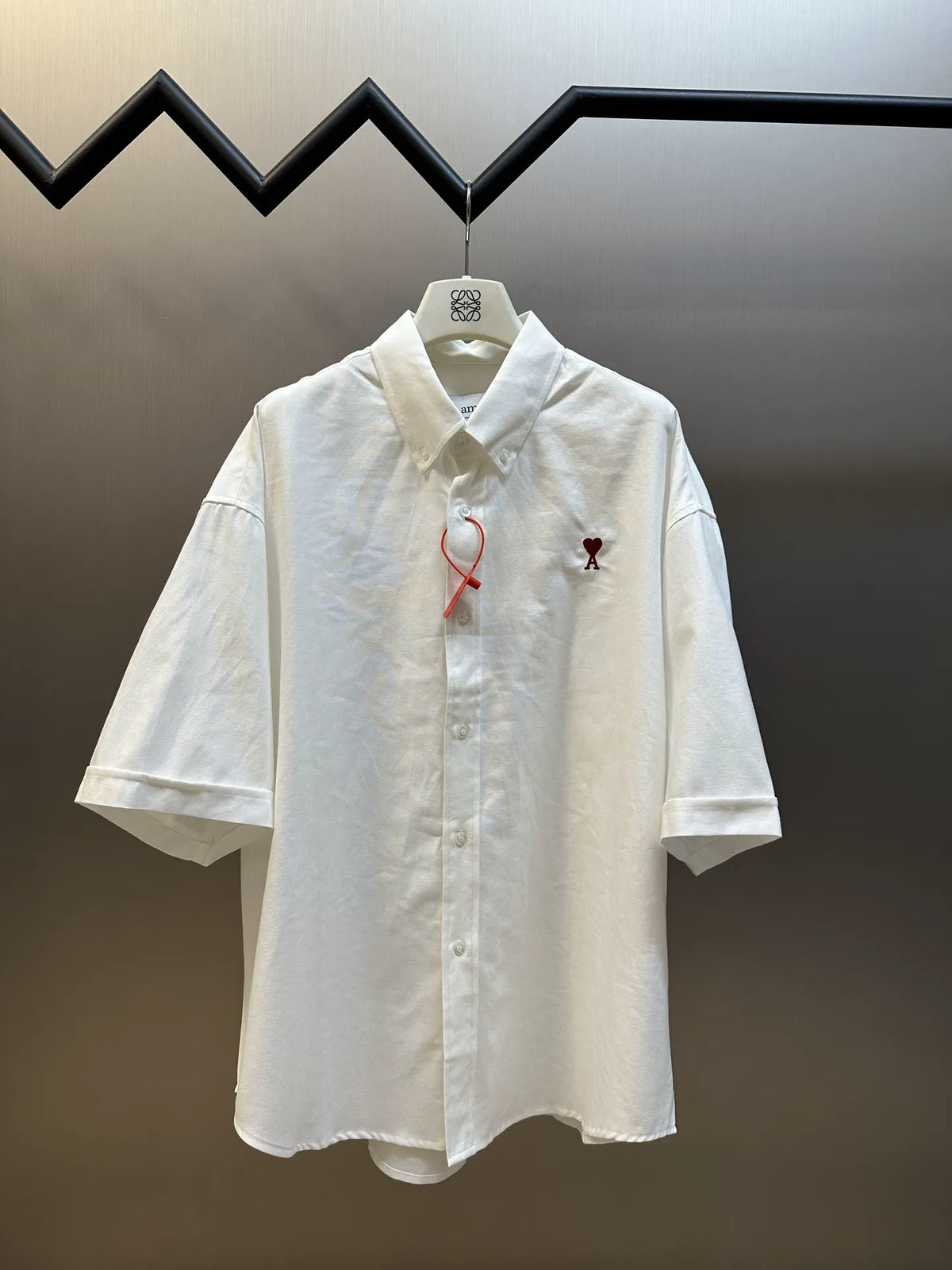 White short-sleeve button-up shirt with chest logo embroidery and red tie detail