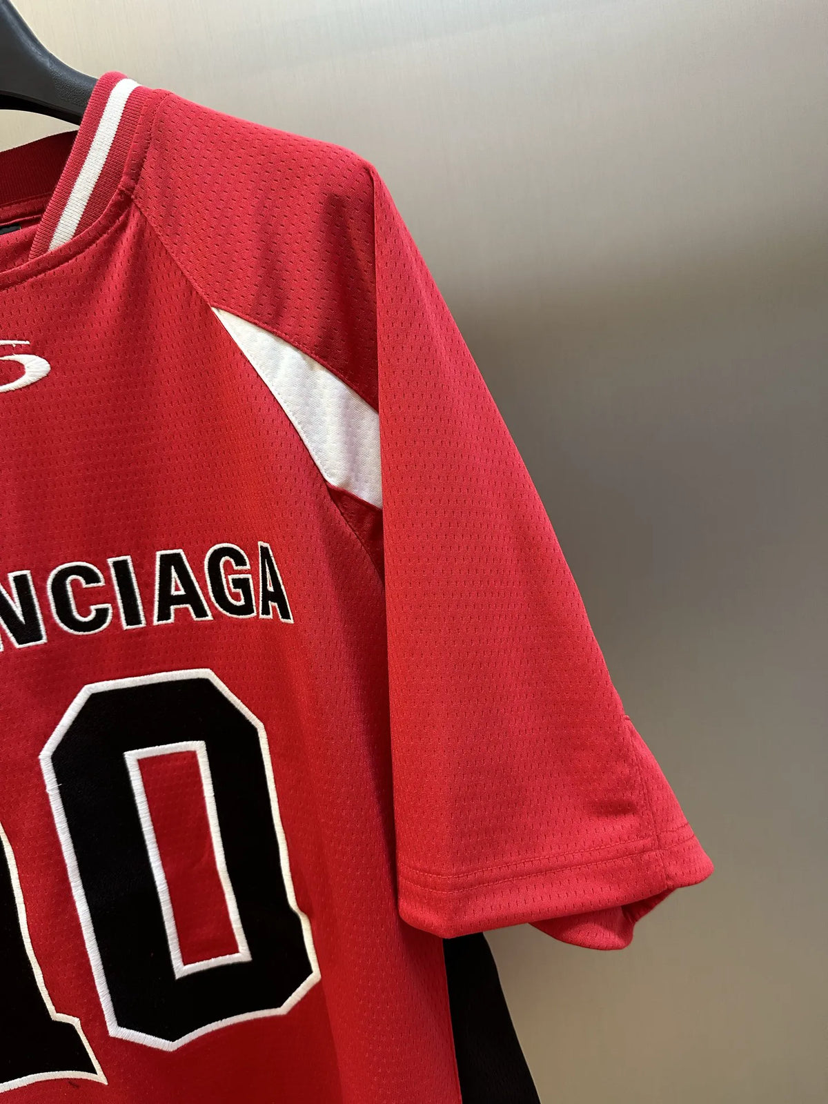 Balenciaga red short-sleeve jersey sleeve detail with white stripe panel and shoulder seam