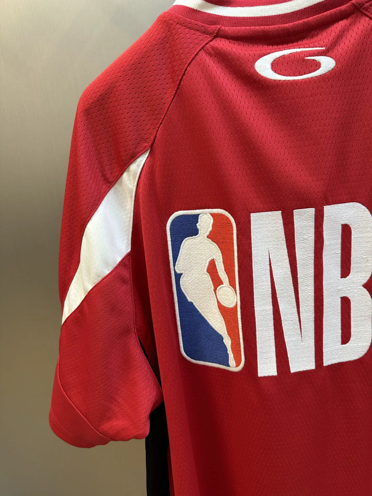 Balenciaga red short-sleeve jersey close-up with NBA basketball logo and white side stripe