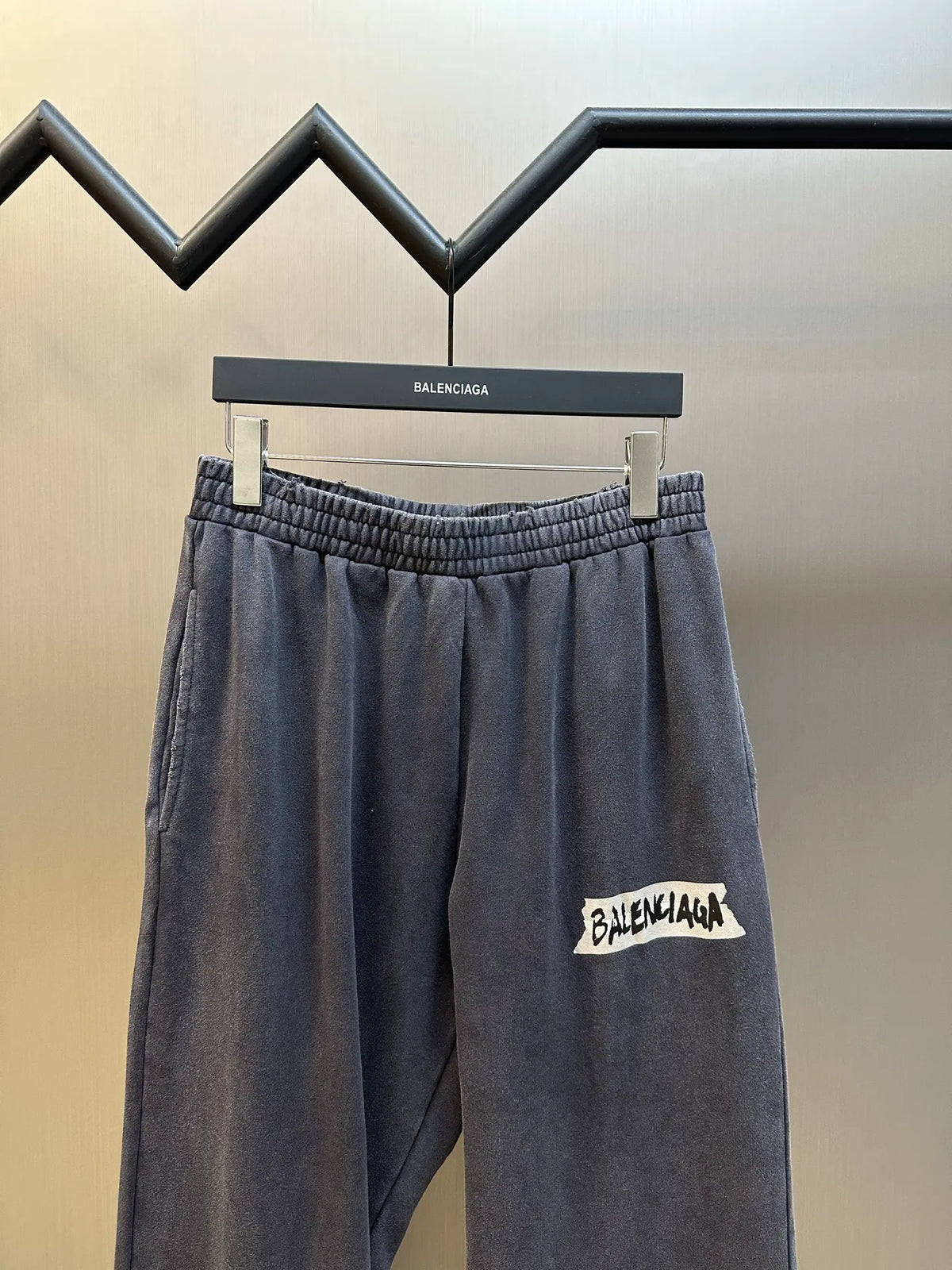 Dark blue wide-leg pants with elastic waistband and Balenciaga logo patch on the leg