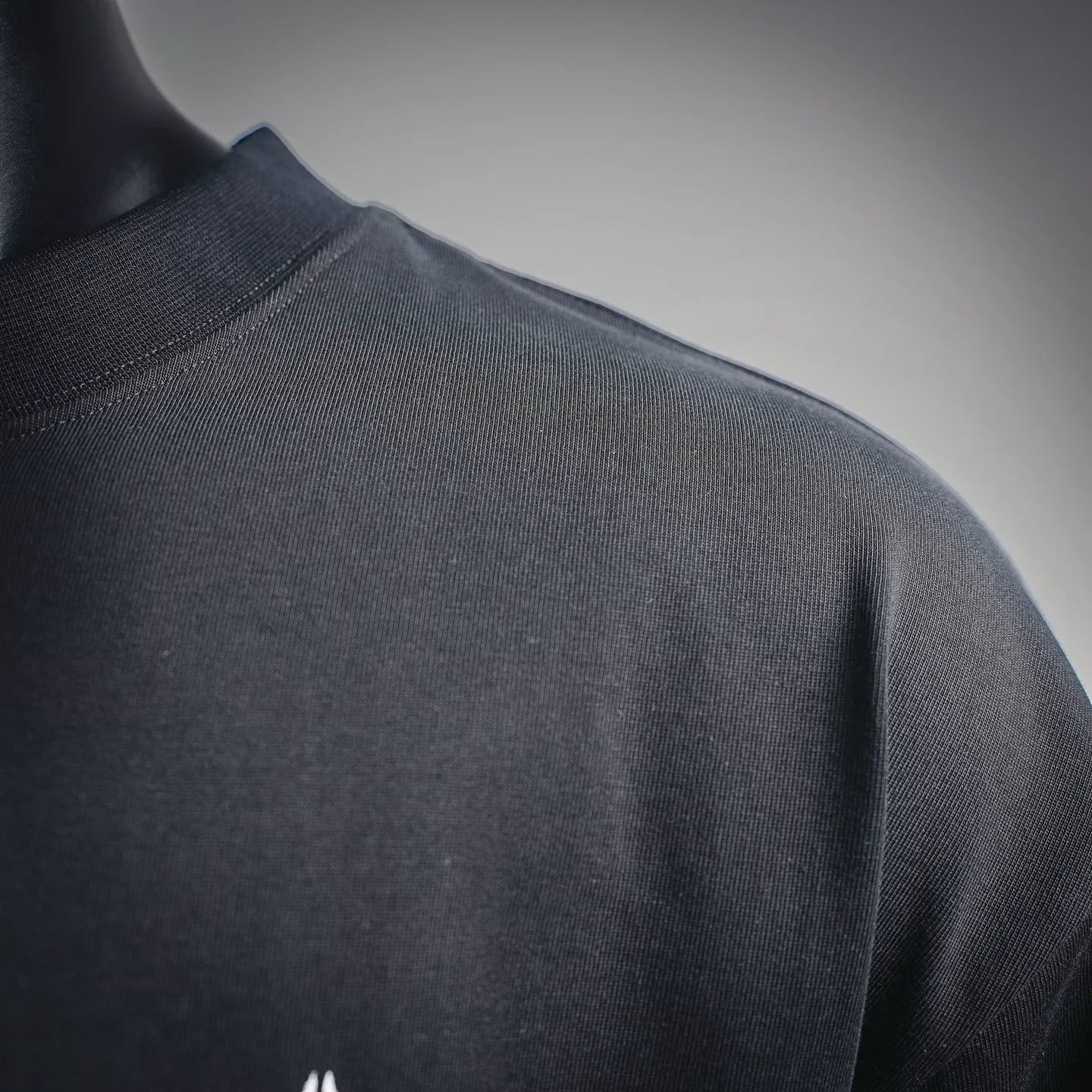 Black long-sleeve turtleneck top back view with smooth fabric texture