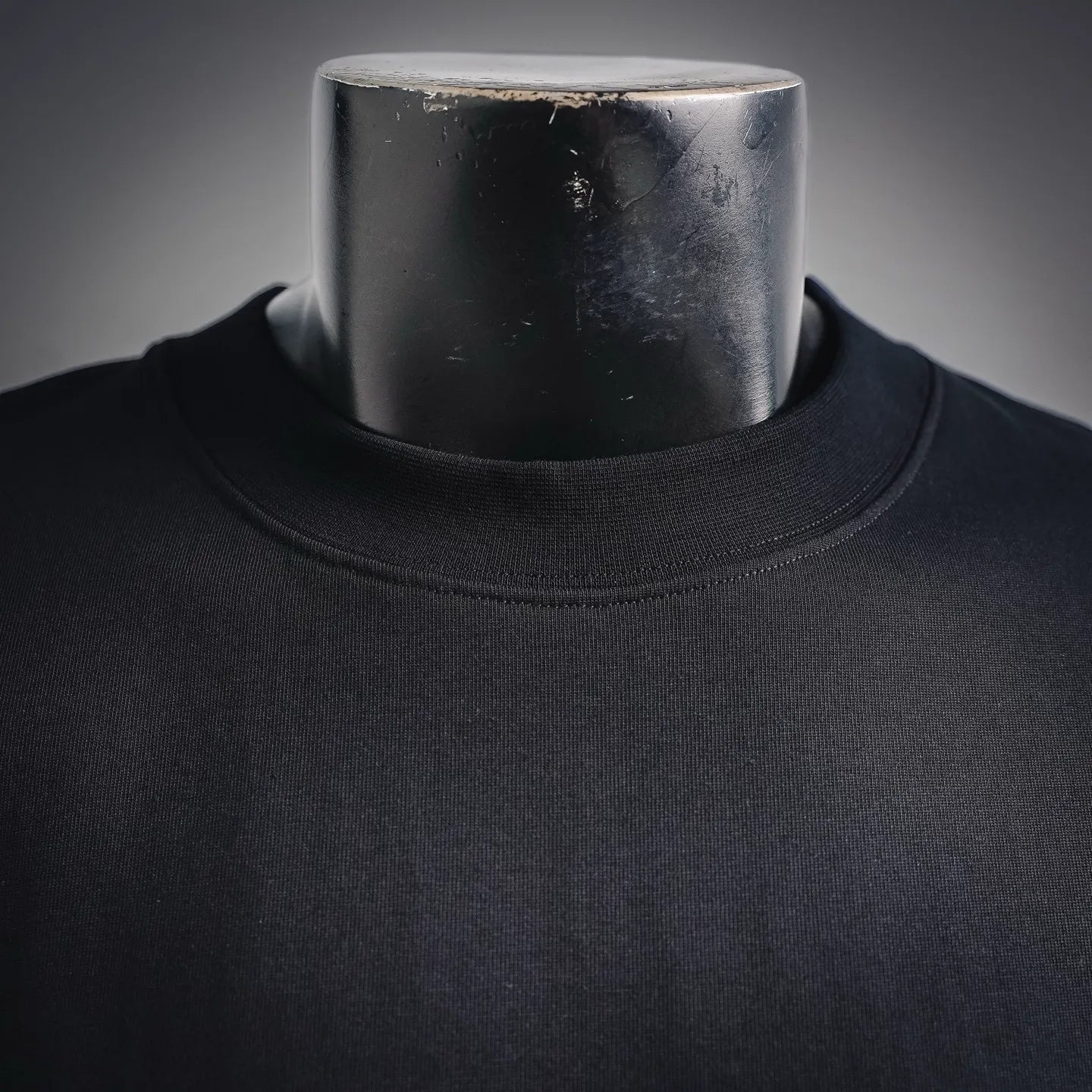 Black long-sleeve turtleneck neckline on a mannequin; plain front