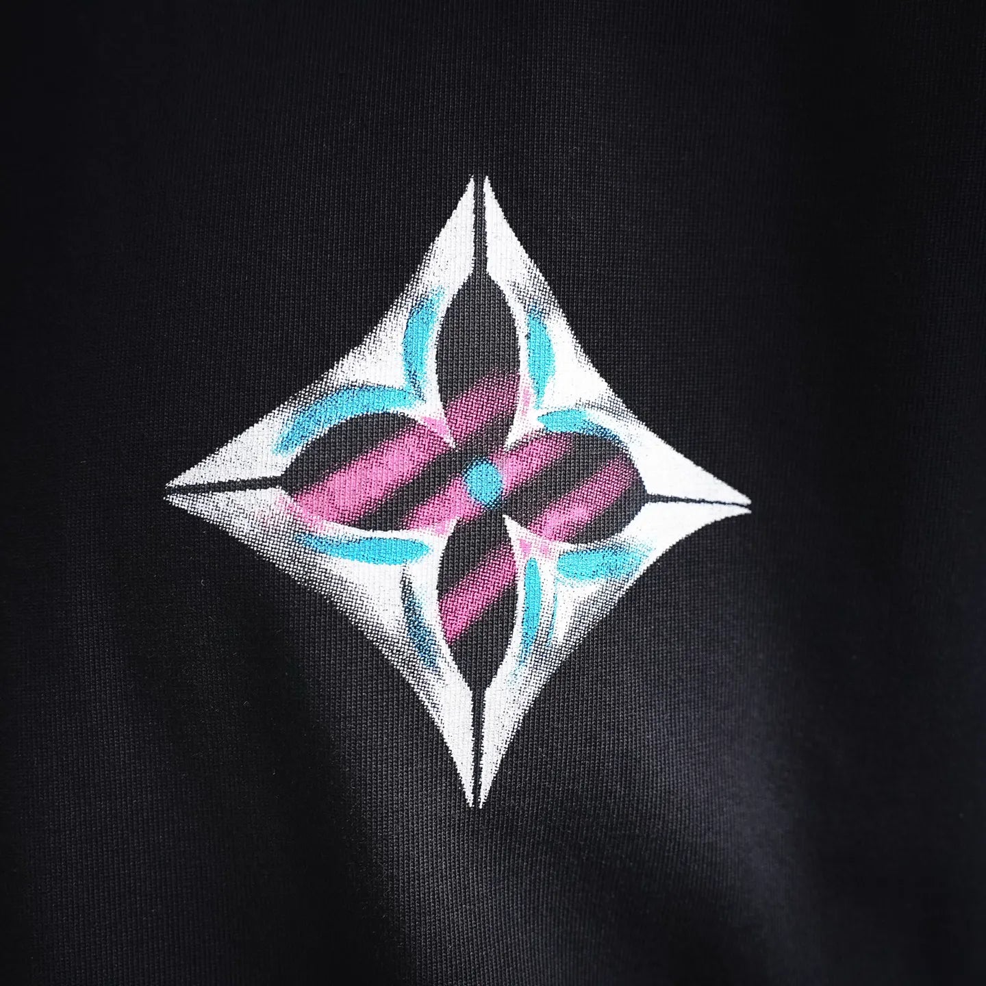 Diamond logo patch on the chest of a black long-sleeve turtleneck top
