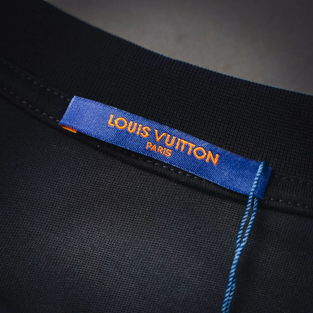 Interior neck label on black long-sleeve top with blue “LOUIS VUITTON” text