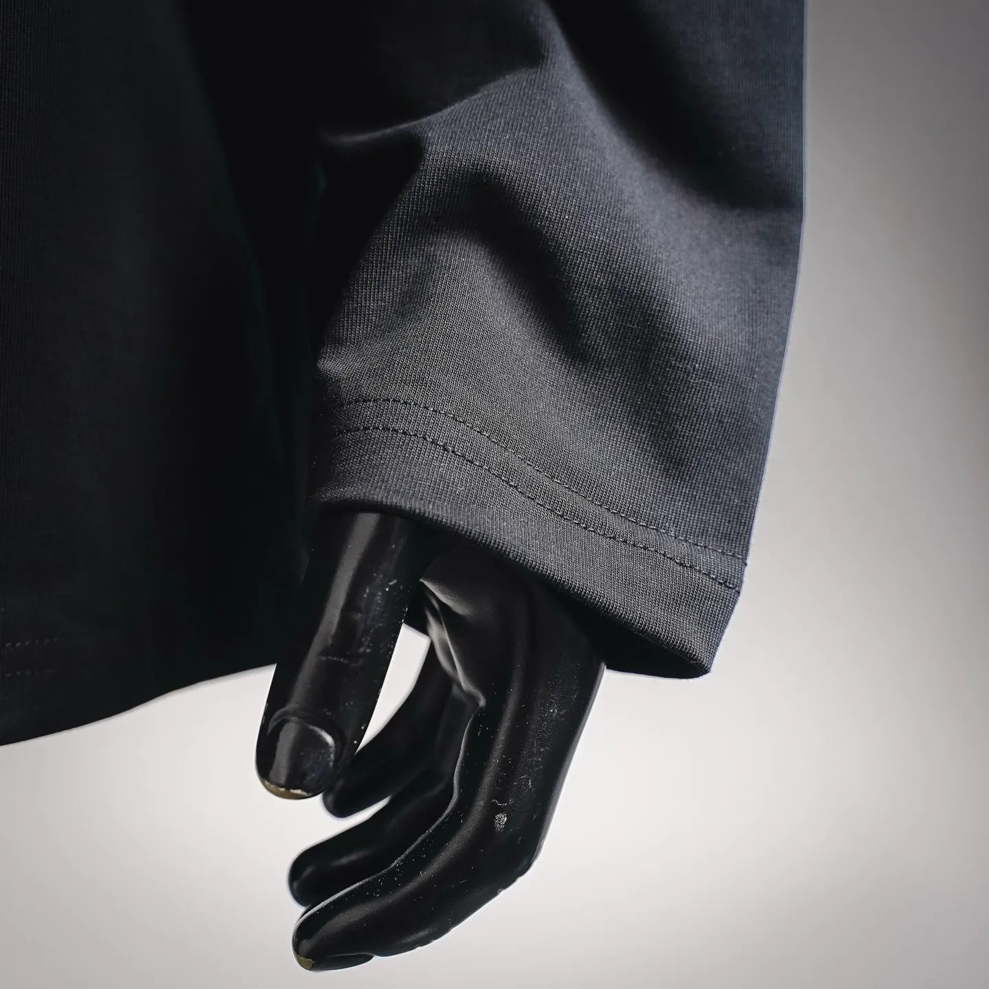 Black long-sleeve top sleeve and cuff detail on a mannequin
