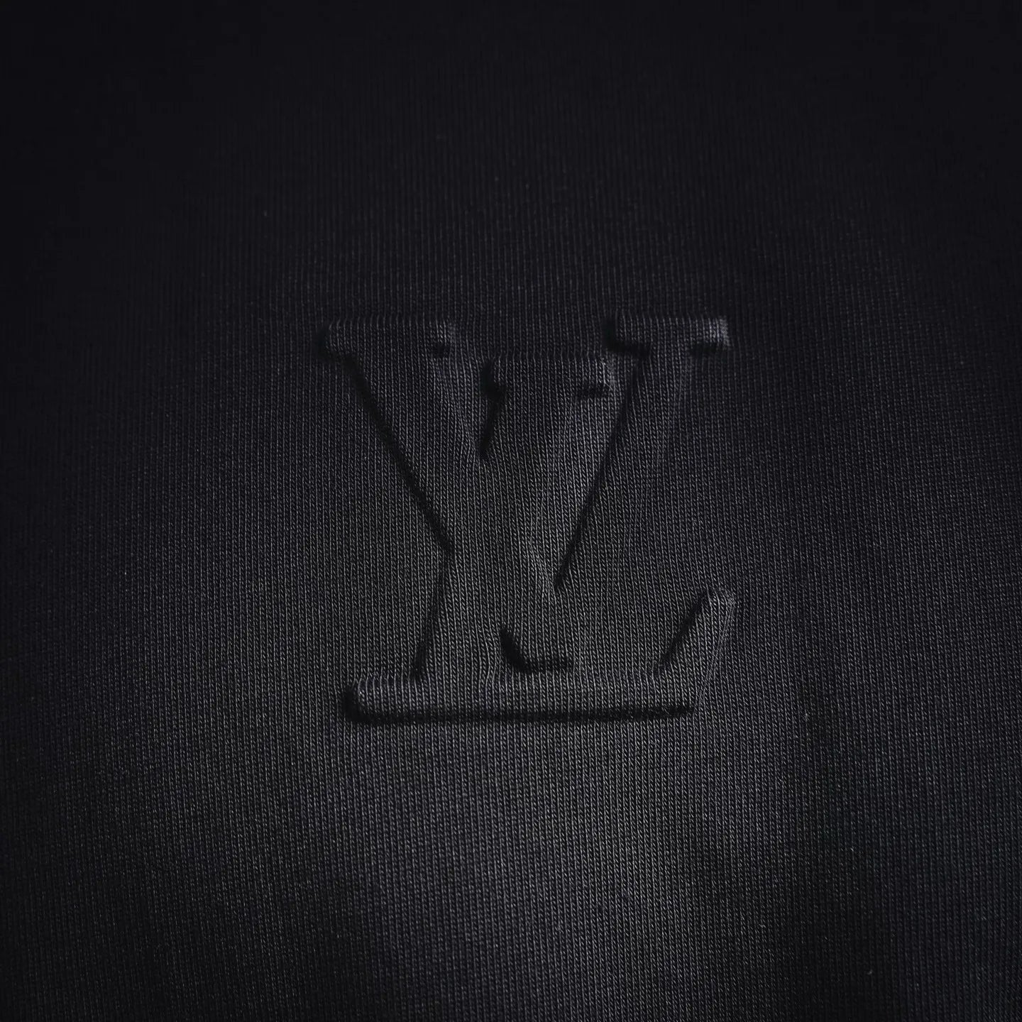 Louis Vuitton LV monogram emblem on black mock neck shirt front