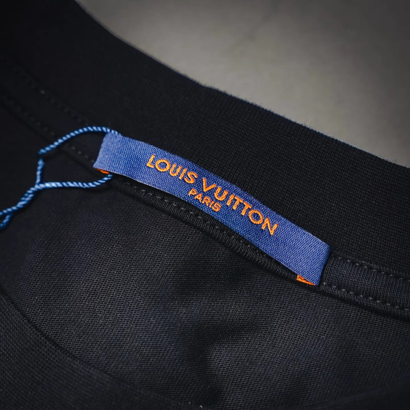 Louis Vuitton collar interior label with blue strip on black mock neck shirt