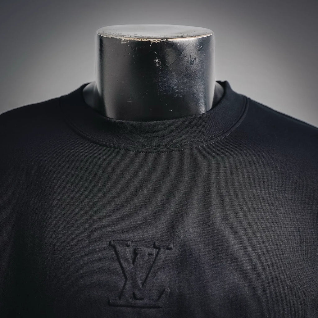 Louis Vuitton LV monogram on black mock neck shirt, close-up at chest