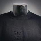 Louis Vuitton LV monogram on black mock neck shirt, close-up at chest