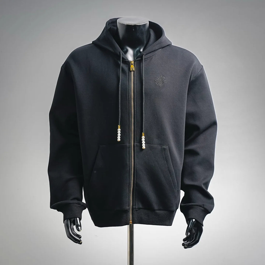Black zip-up hoodie with hood, front pockets, gold zipper, pearl drawstring pulls