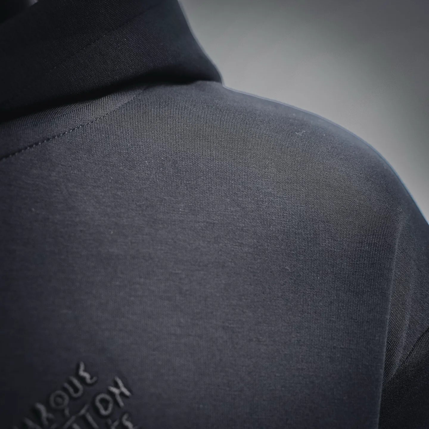 Black hoodie shoulder with small logo embroidery