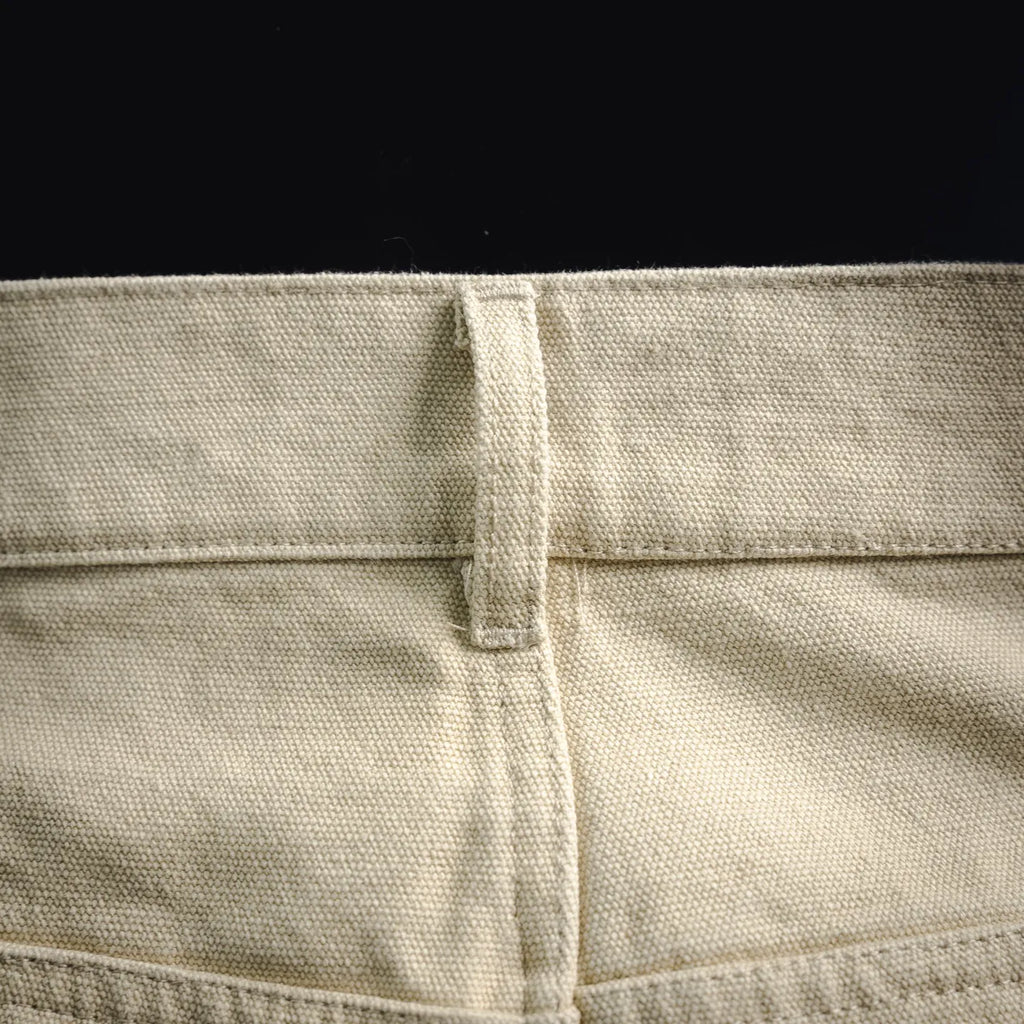 Light beige pants fabric close-up with waistband seam