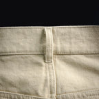 Light beige pants fabric close-up with waistband seam