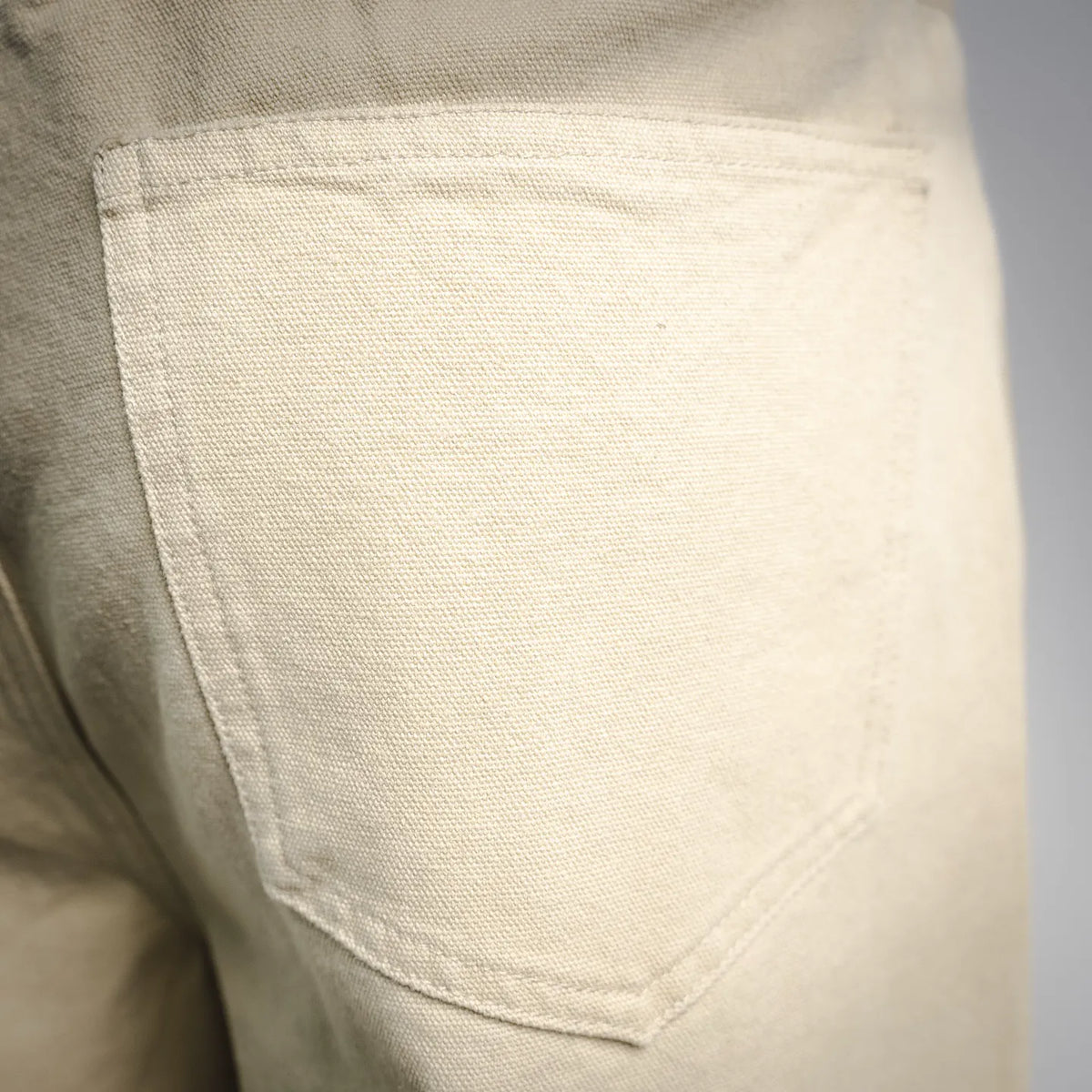 Light beige pants front pocket with stitched curved opening