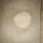 Light beige pants fabric with visible worn spot on leg