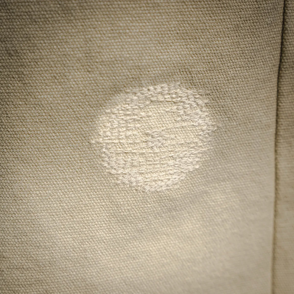 Light beige pants fabric with visible worn spot on leg