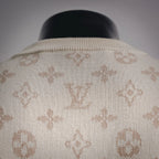 Crew neck ribbed collar of cream sweater with LV monogram pattern.