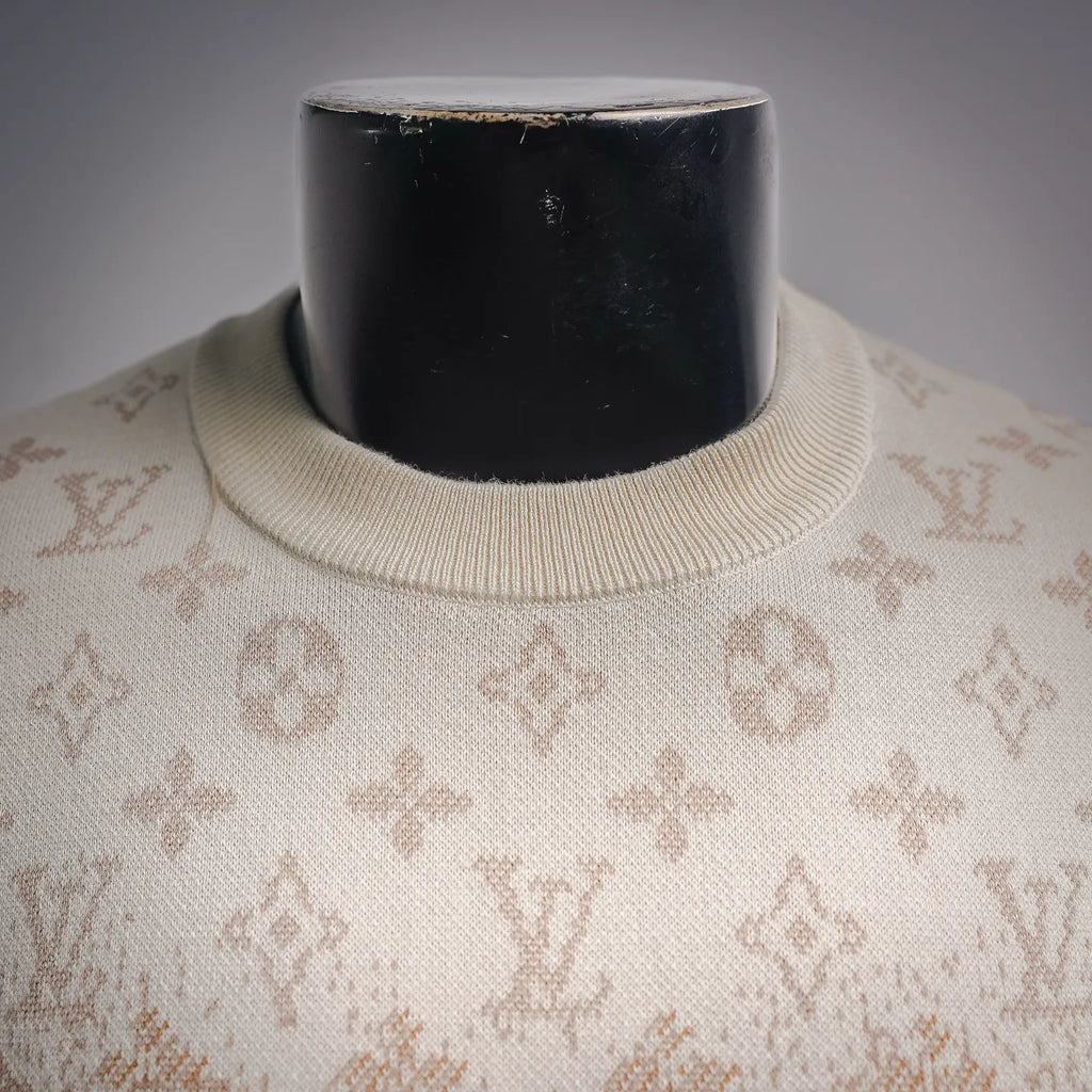 Ribbed crew neck on beige sweater with repeating LV monogram pattern.