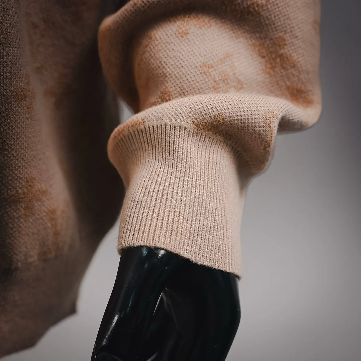 Long-sleeve sweater cuff with ribbed knit and LV monogram pattern.