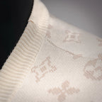 Ribbed knit sleeve edge on cream sweater with LV monogram motifs.
