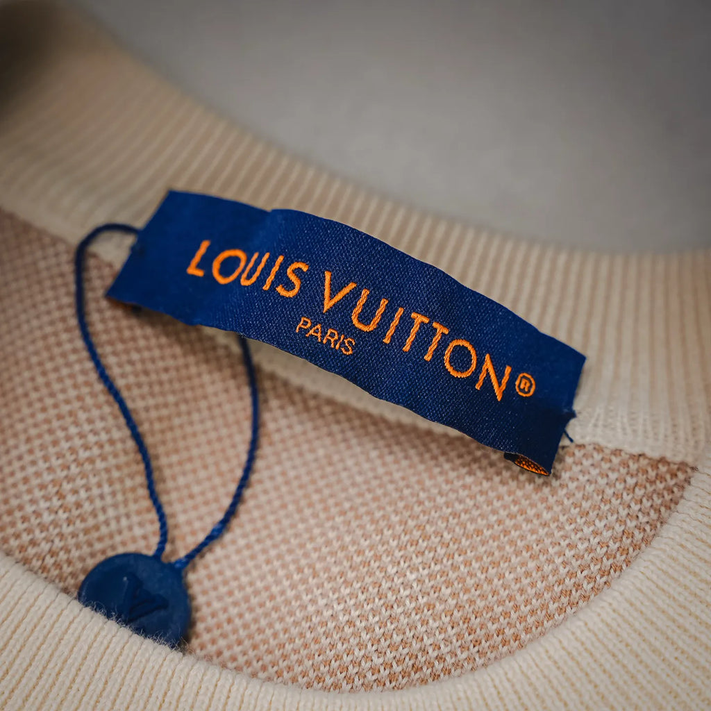 LOUIS VUITTON neck tag on beige long-sleeve sweater with LV monogram knit.