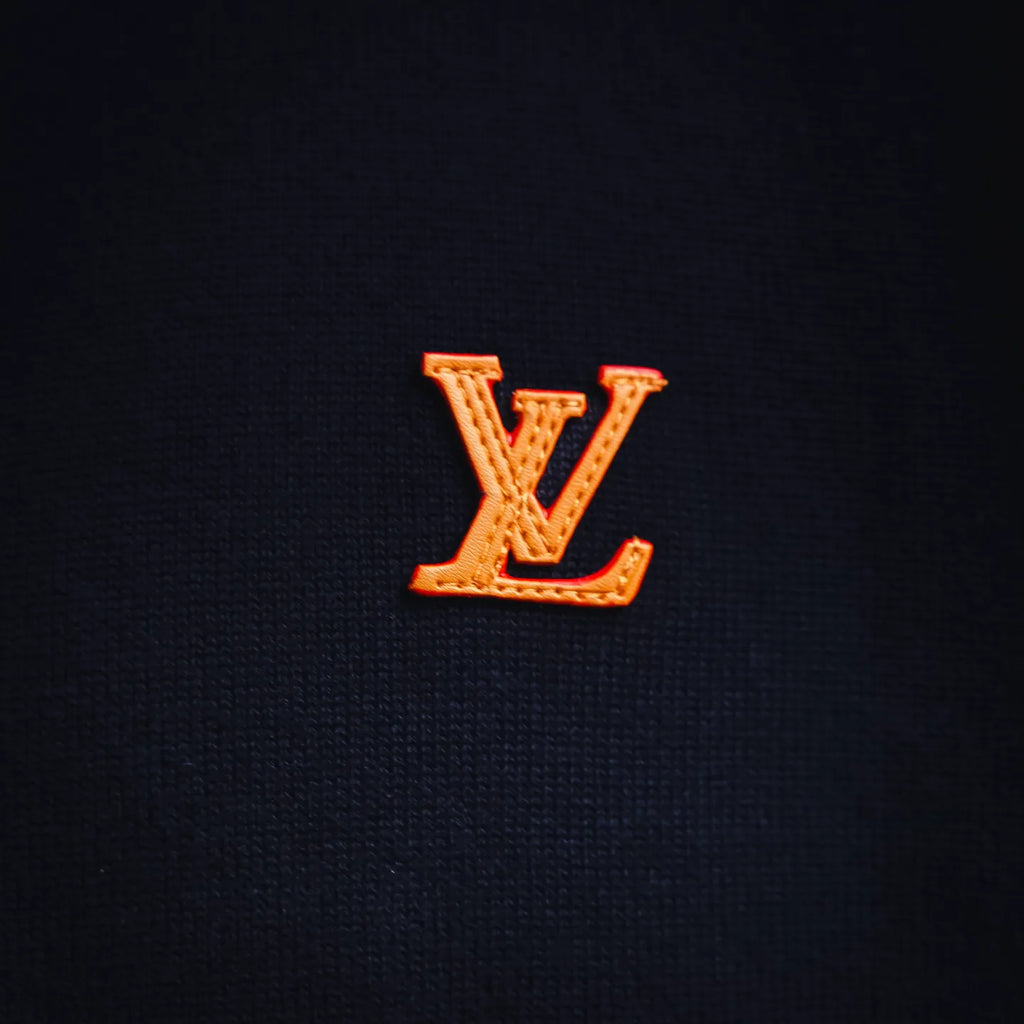 Embroidered LV logo on navy knit fabric of a zip-up coat