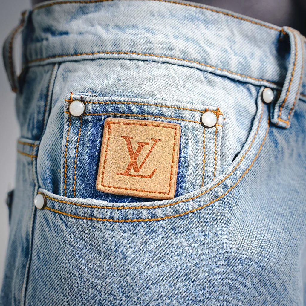 Light blue denim front waistband with tan LV leather patch and gold button rivets