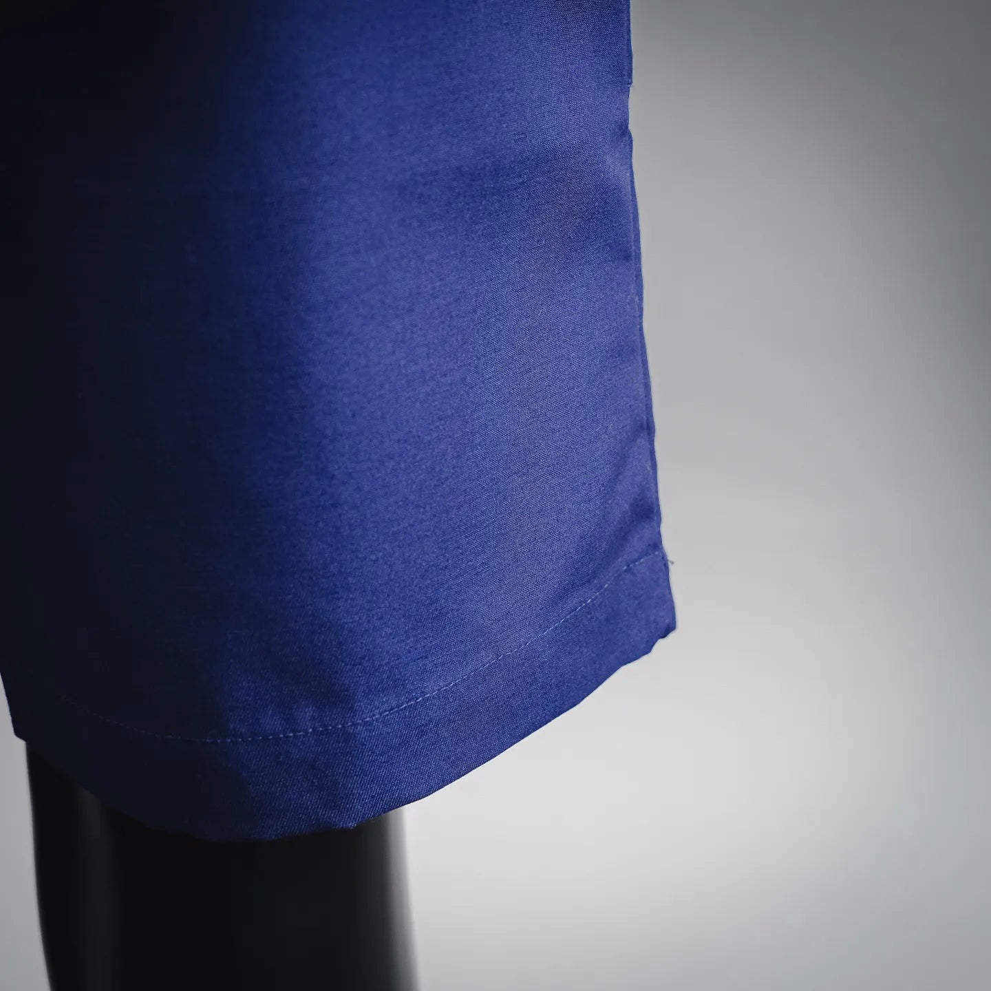 Blue shorts-style pants hem with fabric drape detail