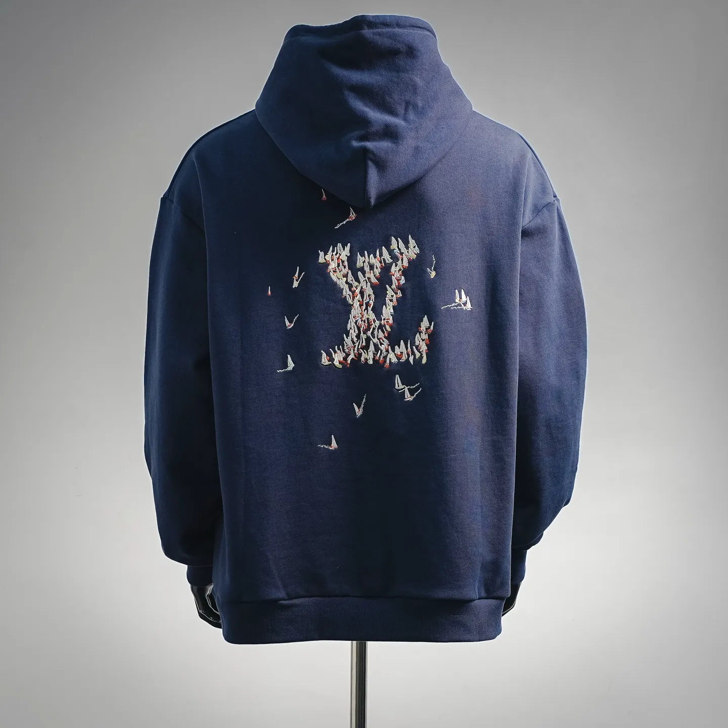 Navy hoodie with embroidered bird graphic on back and drawstring hood