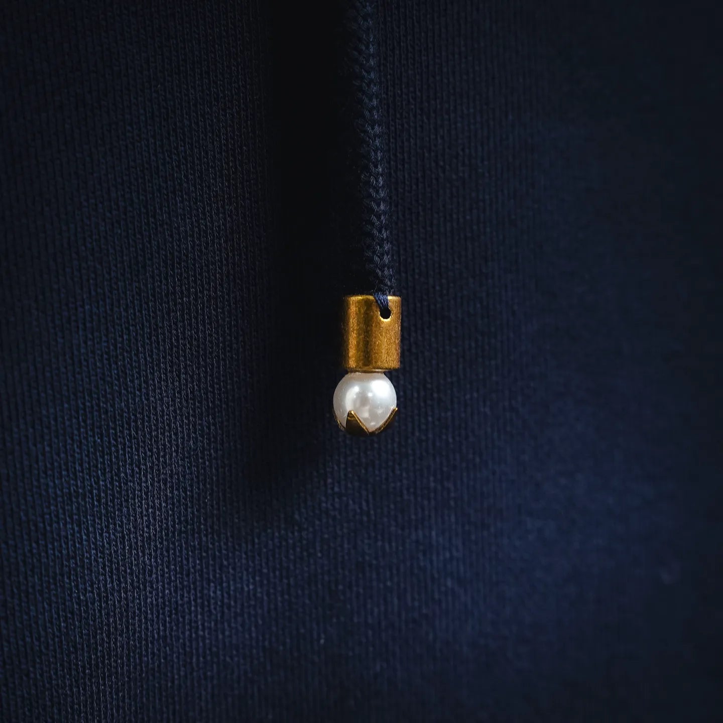 Hoodie drawstring with small metal charm at the end