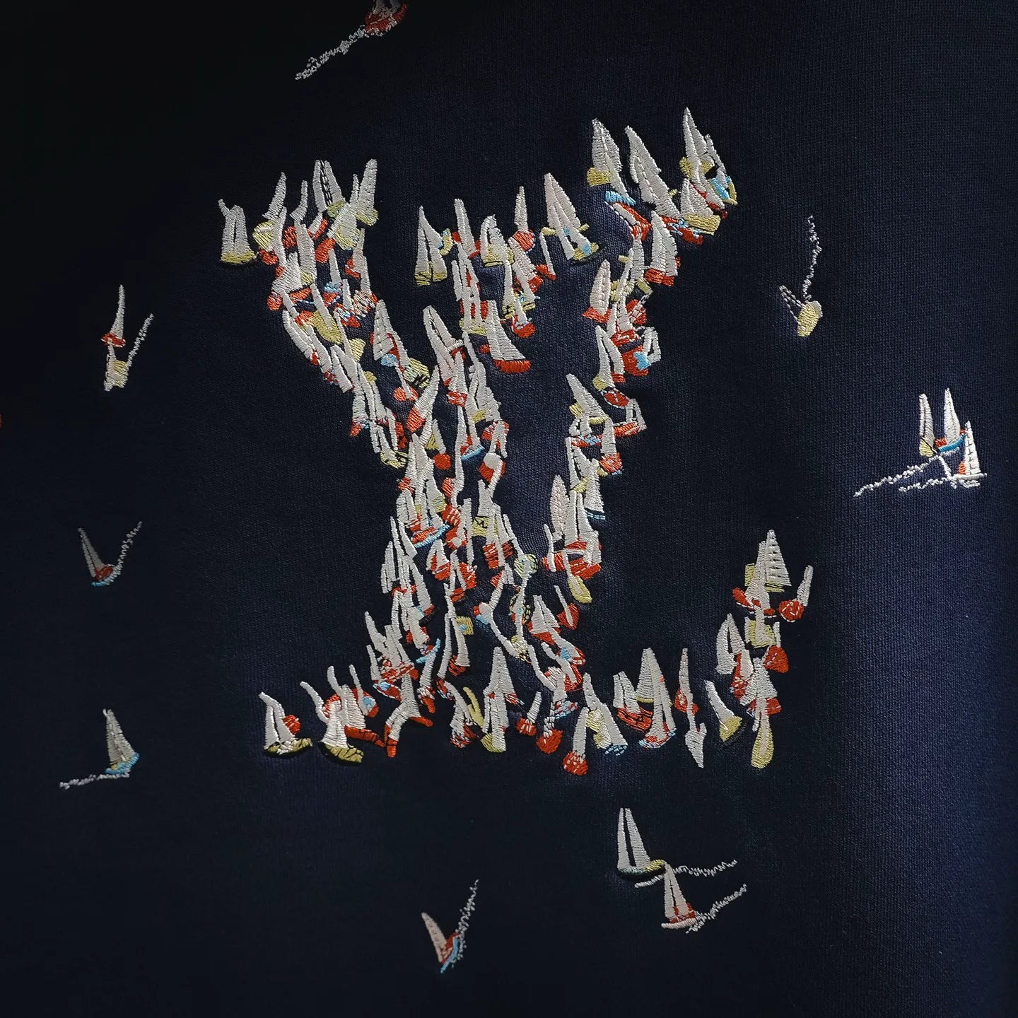 Navy hoodie back with dense embroidered bird graphic