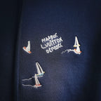 Navy hoodie with embroidered text and small sailboat motifs