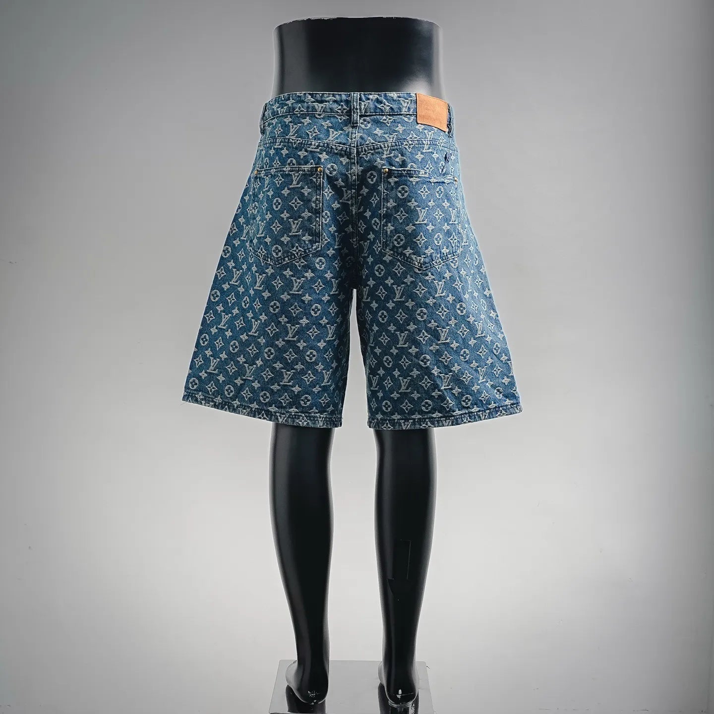 Blue denim shorts with LV-style monogram pattern, rear view and straight hem