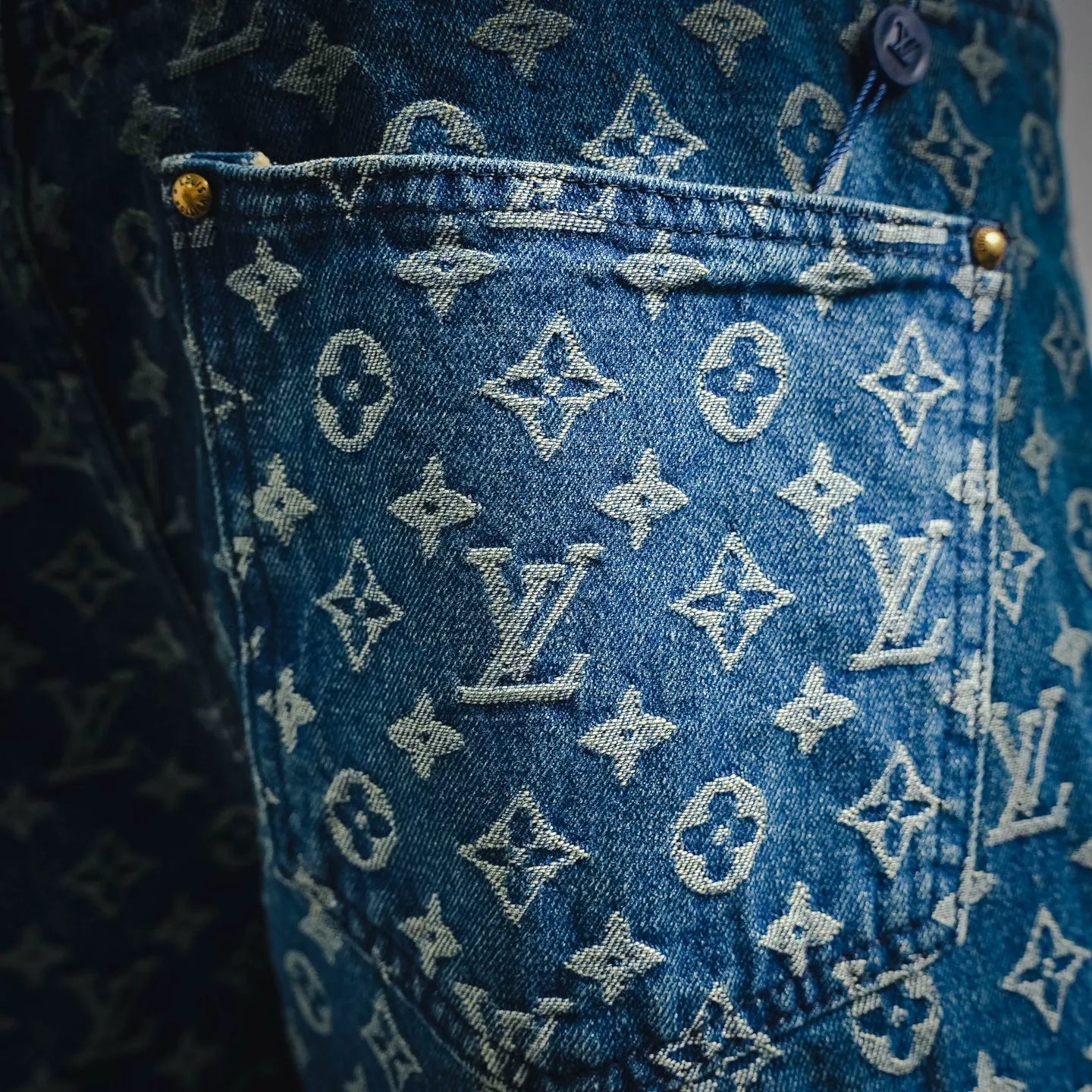 Blue denim shorts with scattered LV monogram print, close-up fabric texture