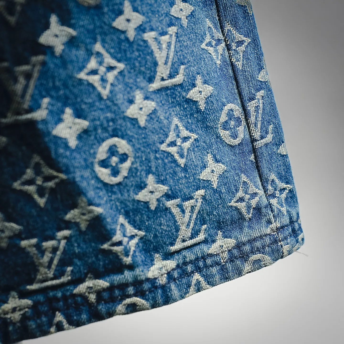 Blue denim shorts side hem with LV monogram pattern, close-up