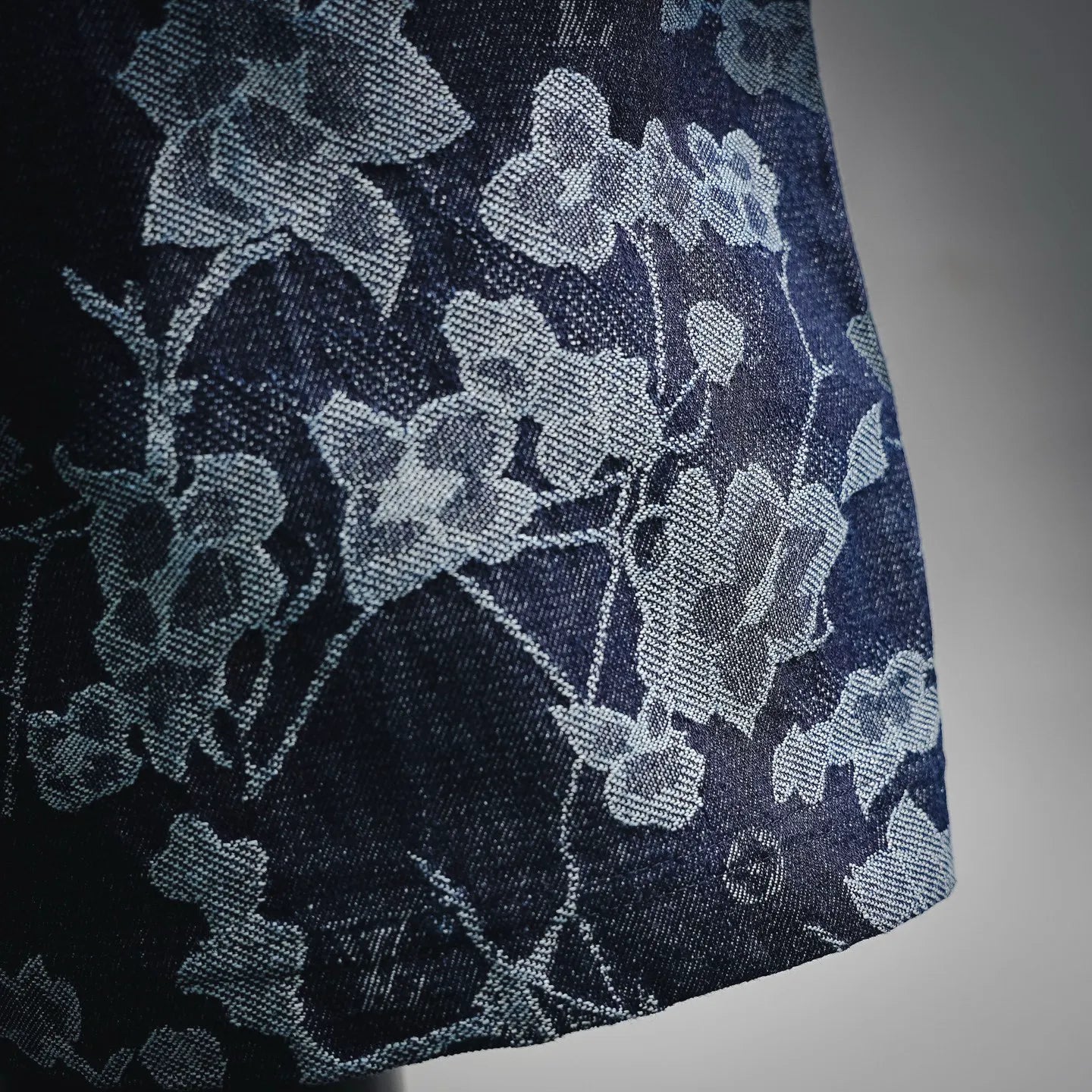 Dark denim fabric with light blue-gray floral pattern