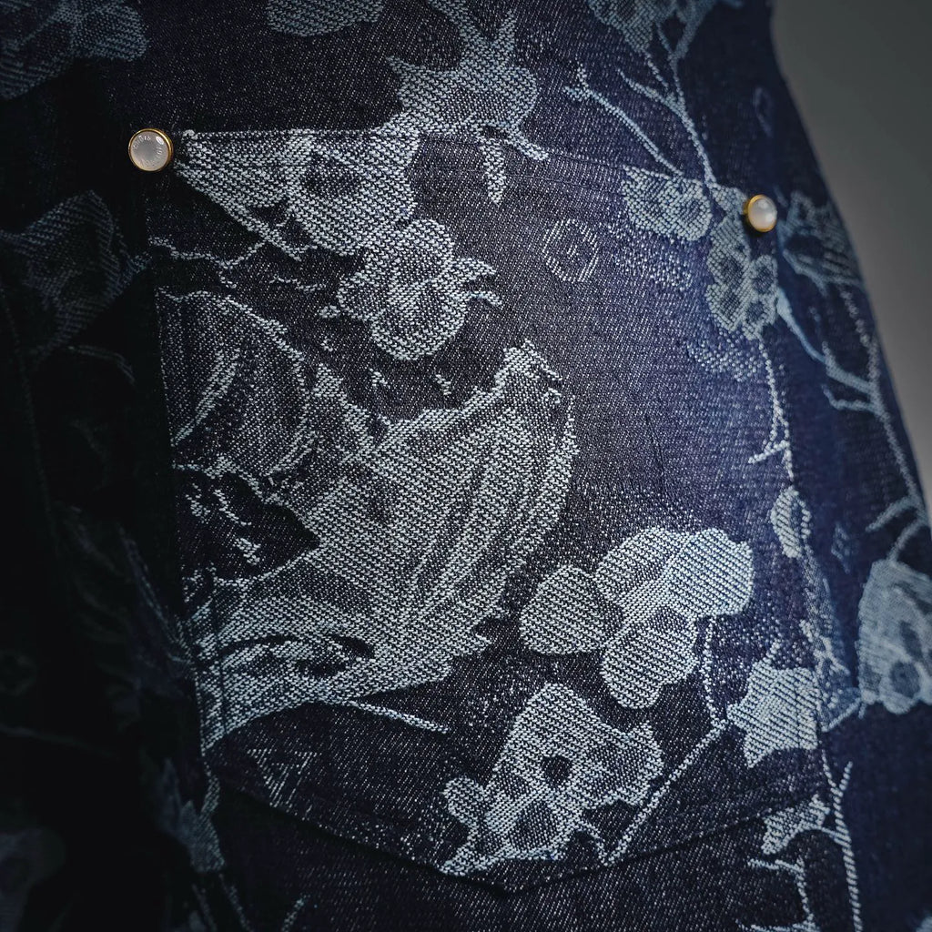 Dark denim pants with floral print and metal button rivets