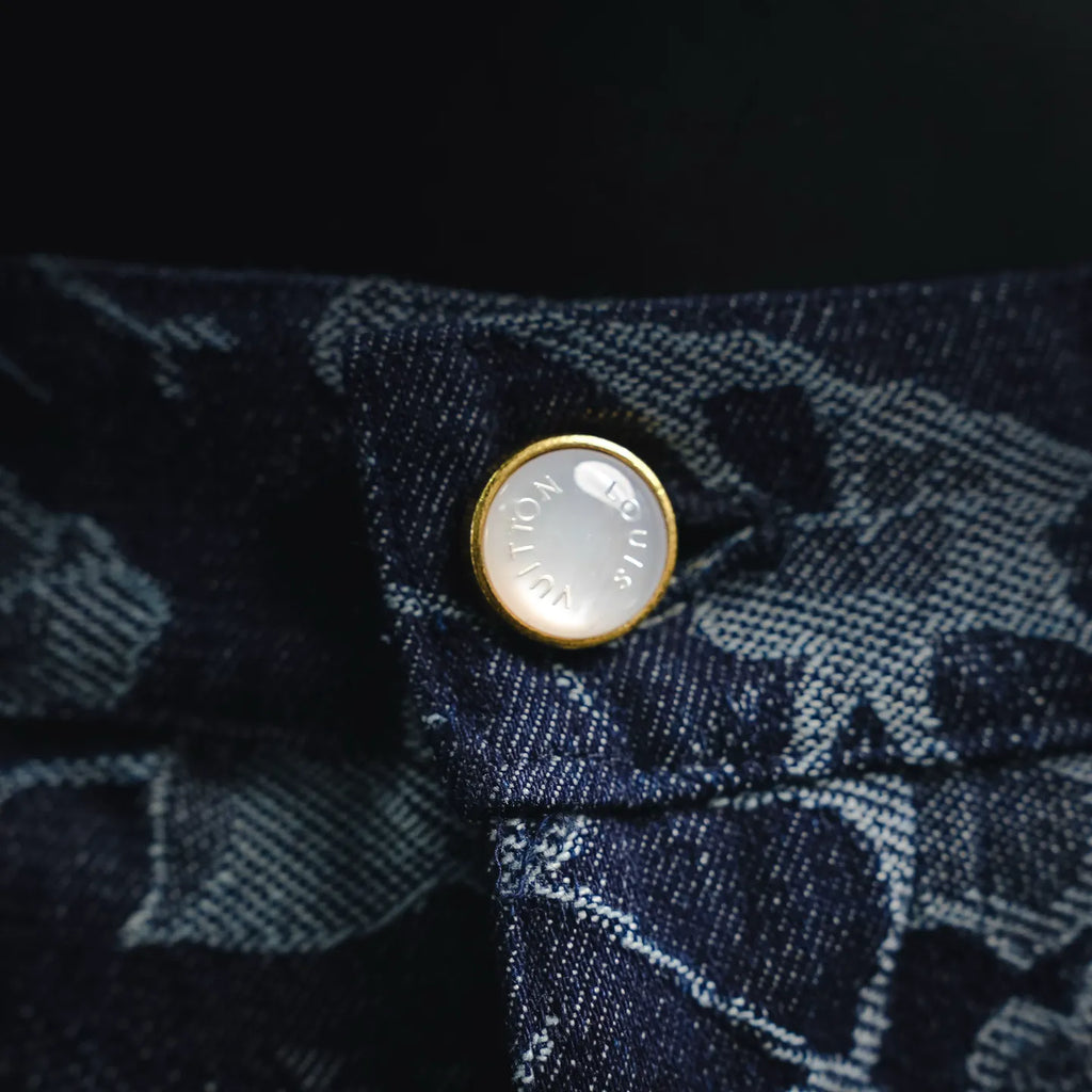 Metal button on dark denim with light floral pattern