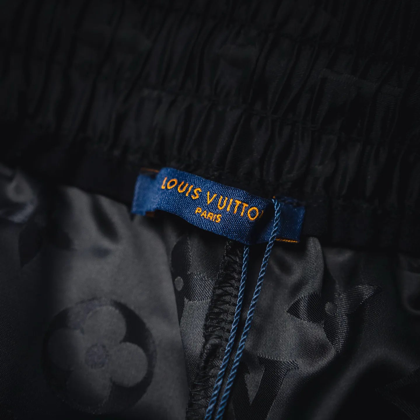 Louis Vuitton shorts size/care tag on black monogram fabric