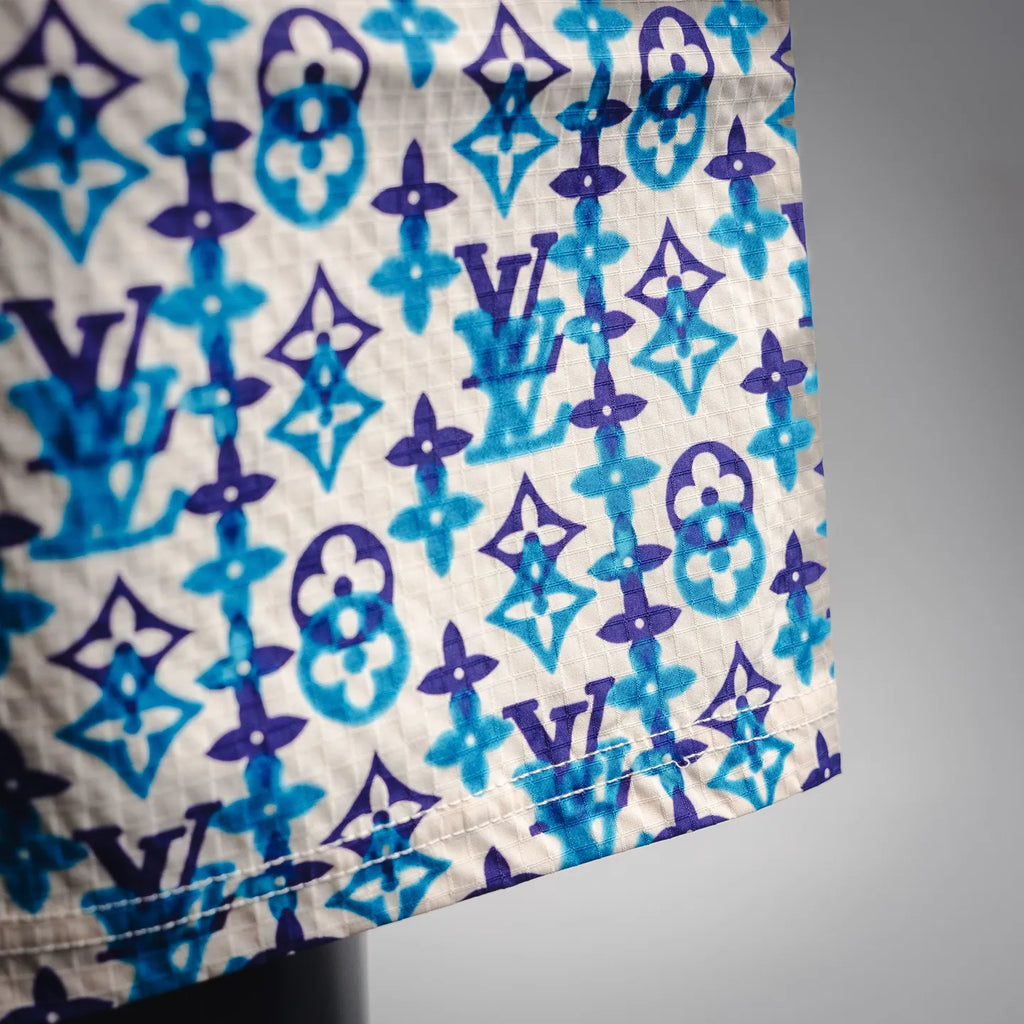 Close-up of blue, navy, and white monogram pattern fabric on shorts