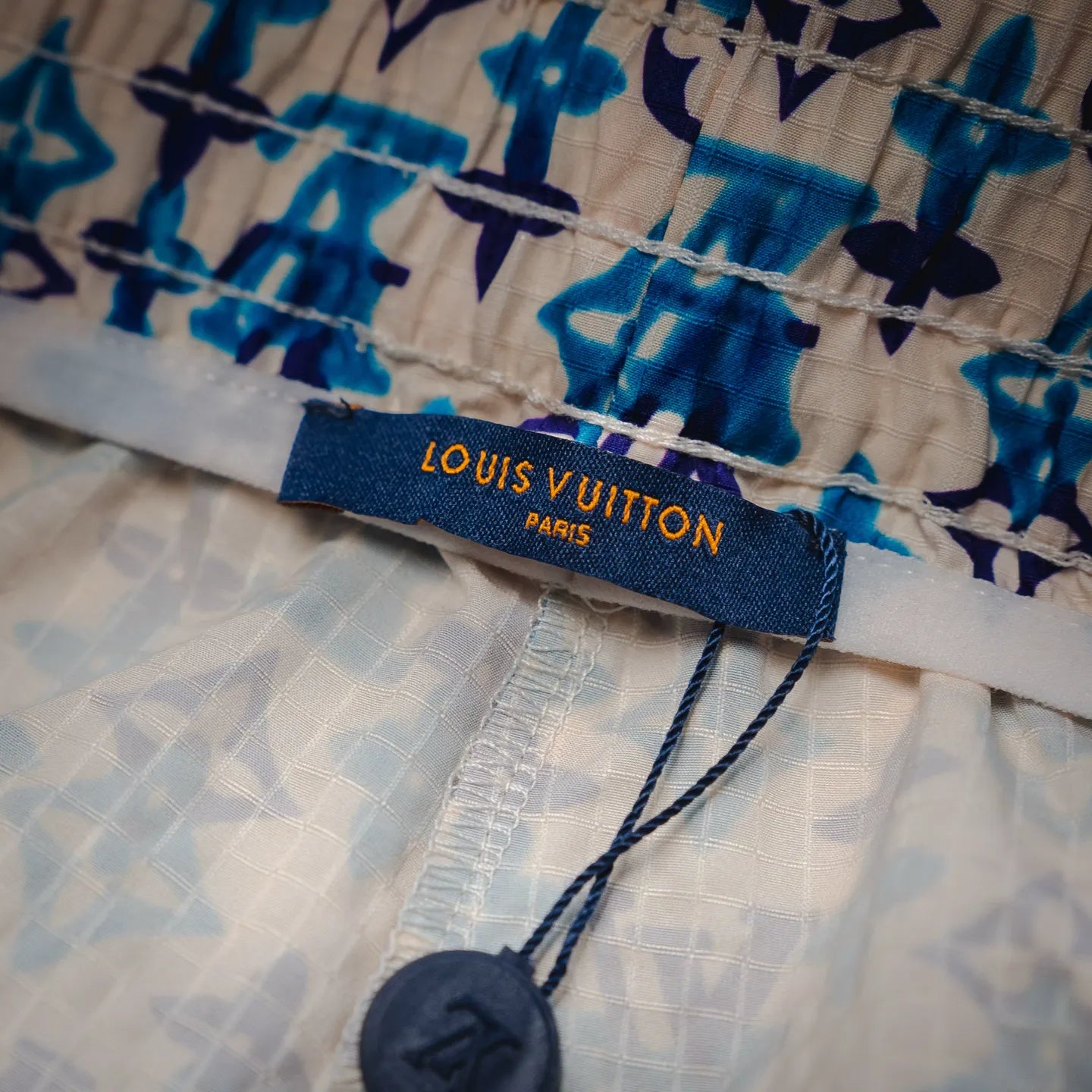 Louis Vuitton Paris label on blue and navy patterned shorts waistband