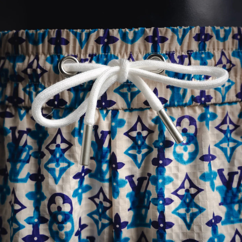 White drawstring with metal aglets on blue and navy monogram shorts