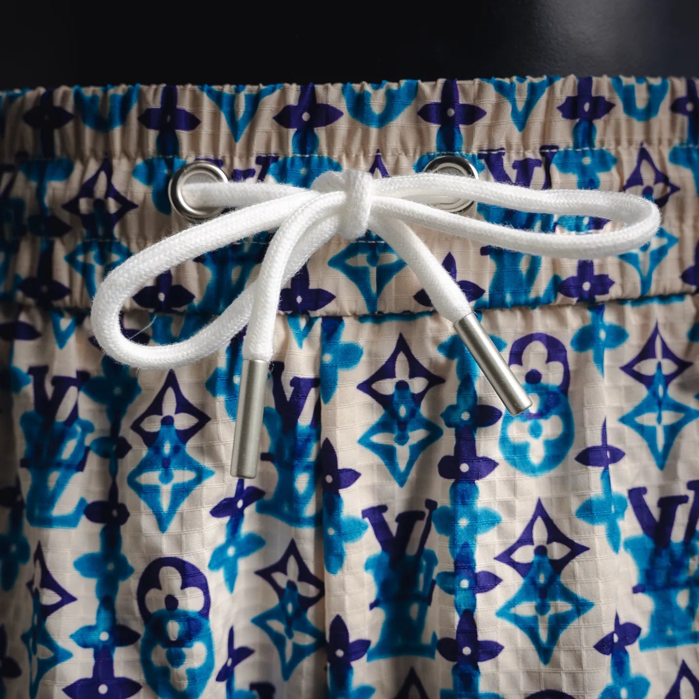 White drawstring with metal aglets on blue and navy monogram shorts