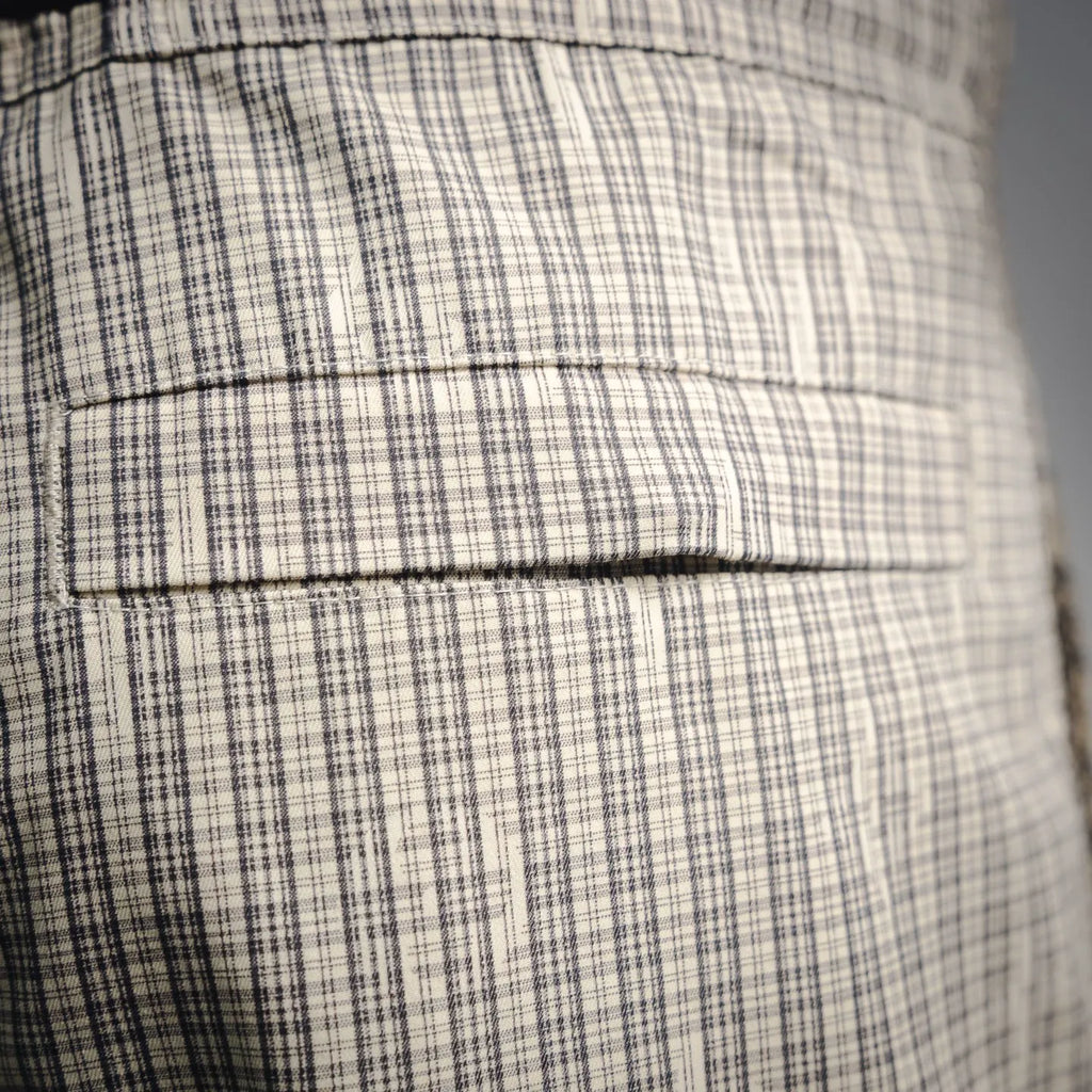 Plaid fabric with stitched seams and folded panel detail