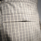 Plaid fabric with stitched seams and folded panel detail