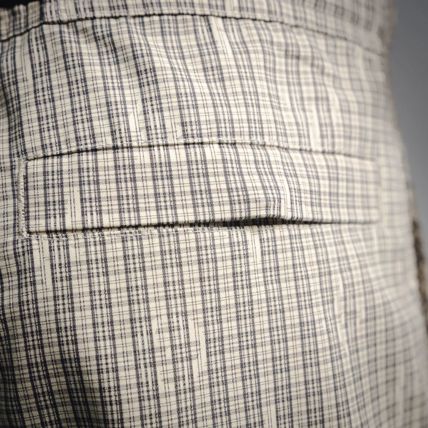 Plaid fabric with stitched seams and folded panel detail