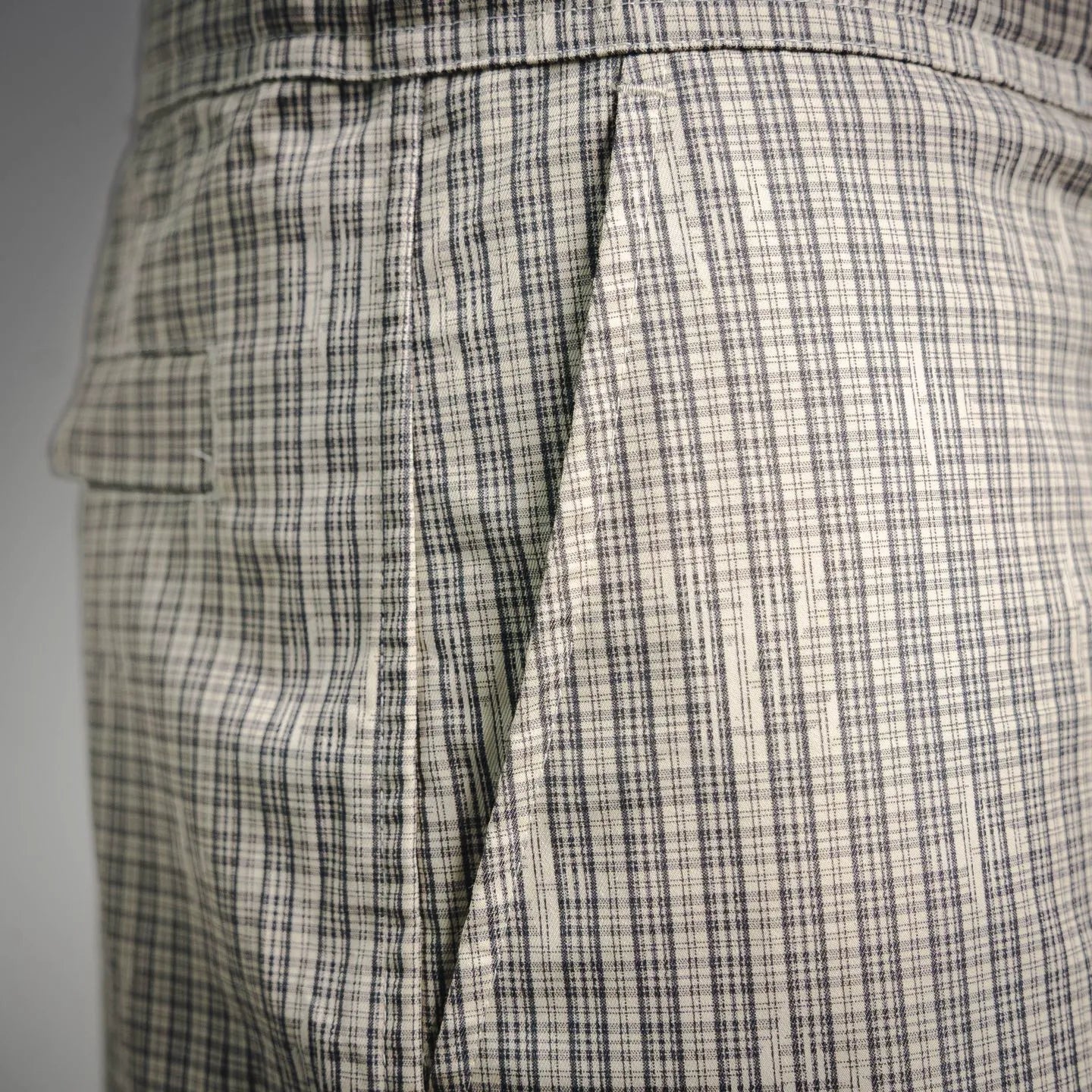 Plaid pants side view with pleats and cargo pocket panel stitching