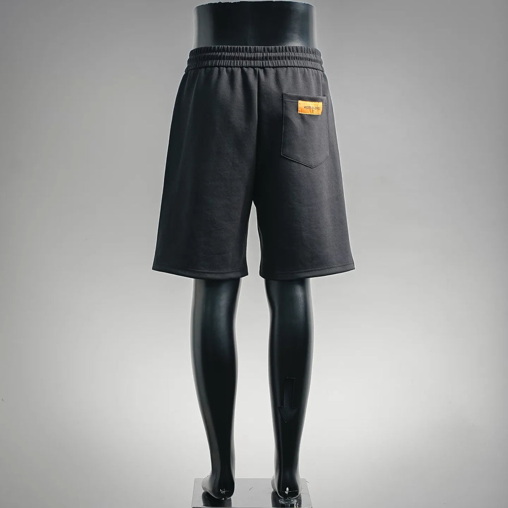 Black drawstring shorts, back pocket with small orange logo patch