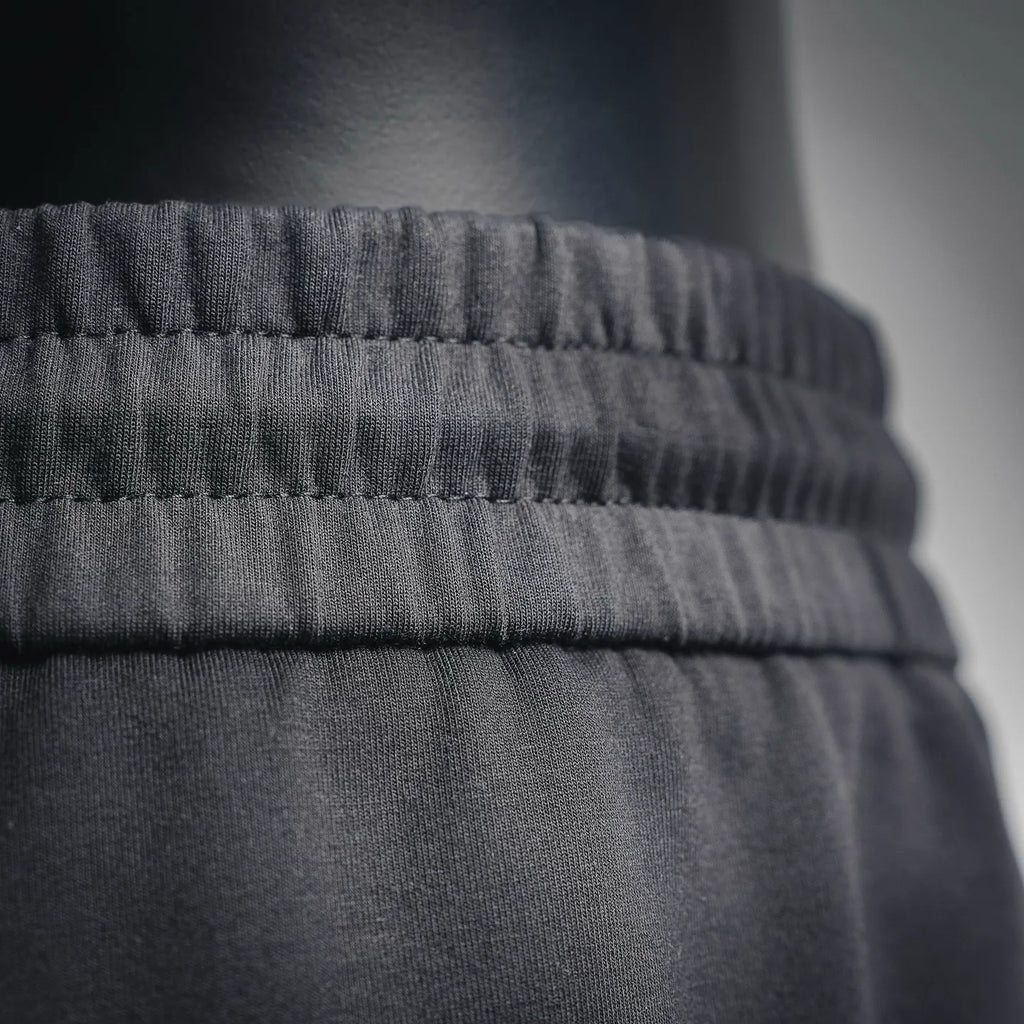 Black elastic waistband with stitched seam and gathered fabric texture