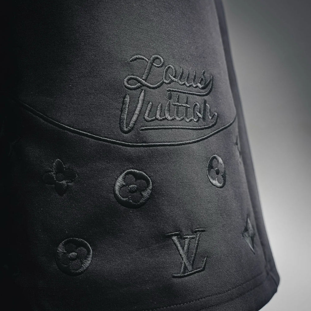 Black shorts with 'Louis Vuitton' script and small LV monogram emblems